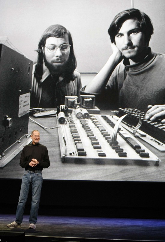 Steve Jobs em conferência da Apple com um retrato antigo dele e de Steve Wozniak no telão ao fundo (Paul Sakuma - 27.jan.2010/Associated Press