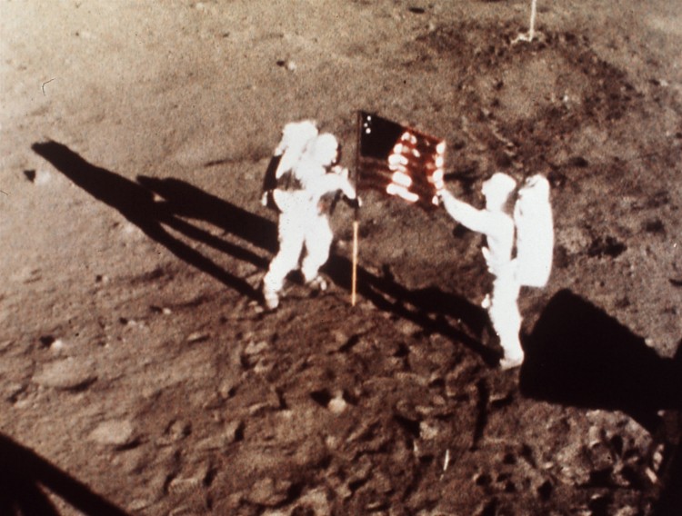 ORG XMIT: 123001_1.tif Os astronautas Neil Armstrong e Edwin Aldrin fincam bandeira dos EUA na Lua, em julho de 1969. Apollo 11 astronauts Neil Armstrong and Edwin E. "Buzz" Aldrin, the first men to land on the moon, plant the U.S. flag on the lunar surface, July 20, 1969. Photo was made by a 16mm movie camera inside the lunar module, shooting at one frame per second. (AP Photo/NASA)